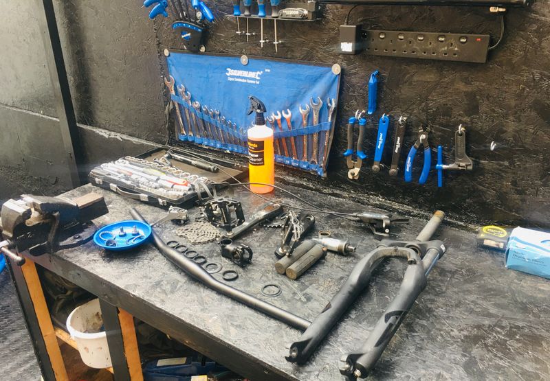 Bike components stripped down on workshop bench during major service