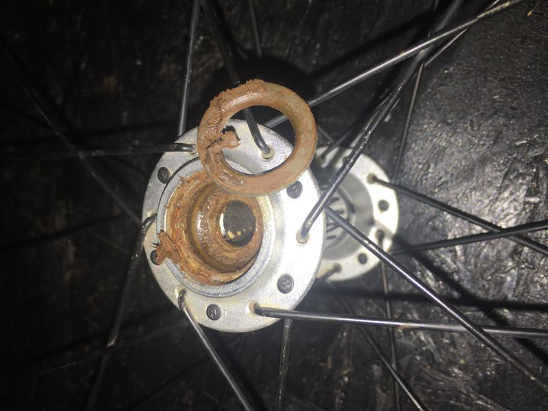 Wheel hub before servicing showing corroded bearings and old grease